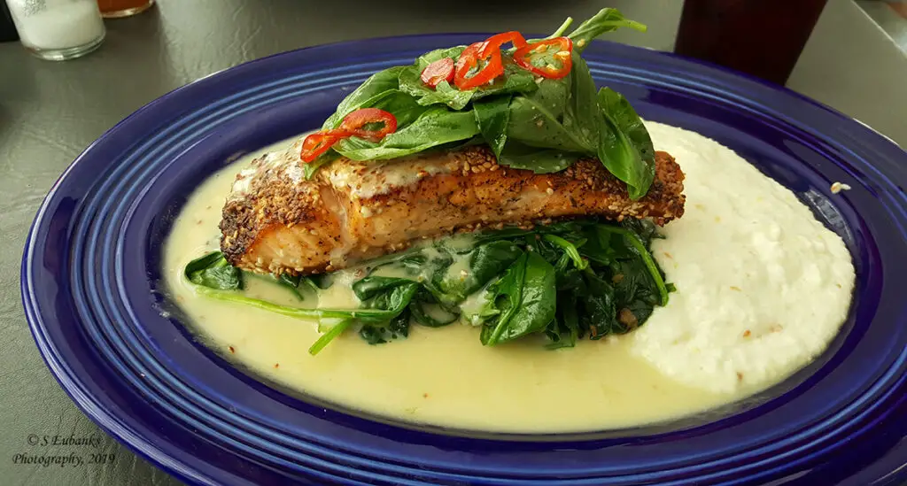 Toasted Sesame Salmon with Grits and Spinach in a blue dish