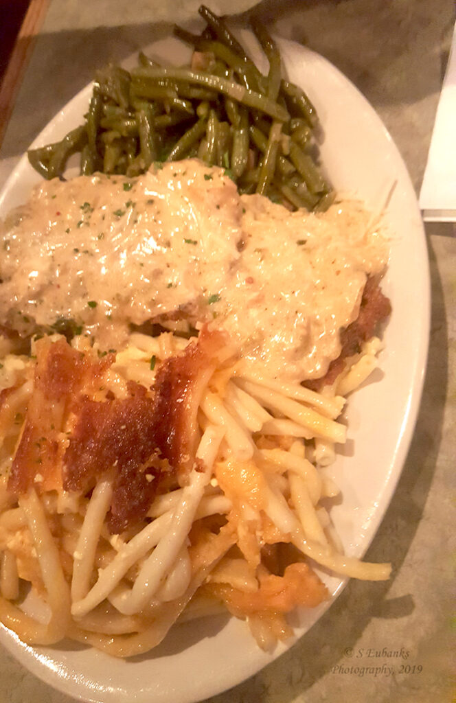 Veal Parmesan and Baked Macaroni with a side of green beans on a white dish