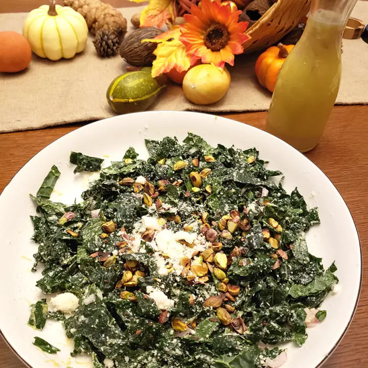 kale salad in a bowl with fall decor in the background