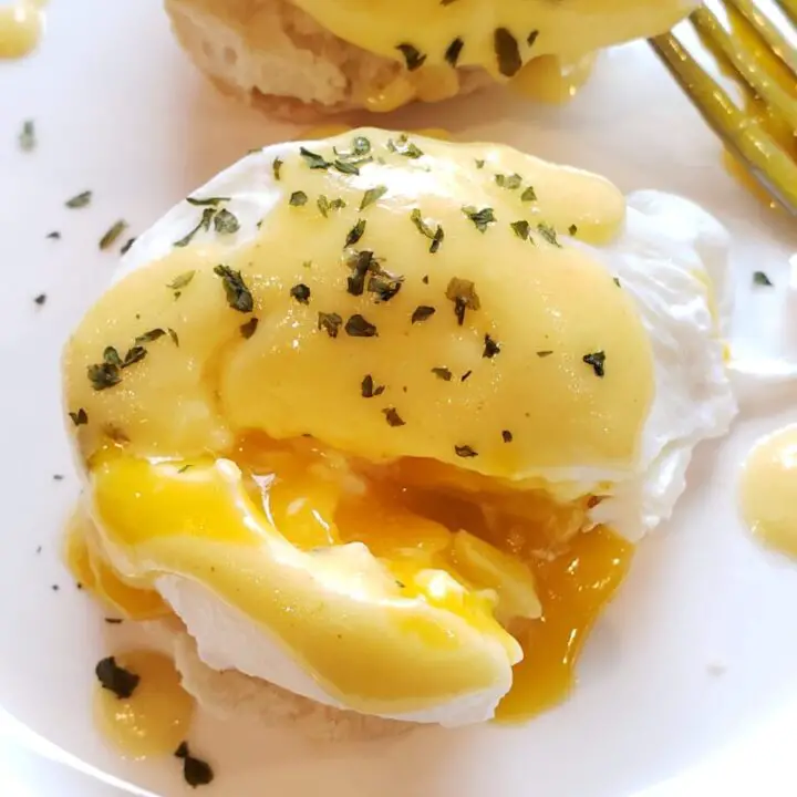 Eggs Benedict on a White Plate with Fork