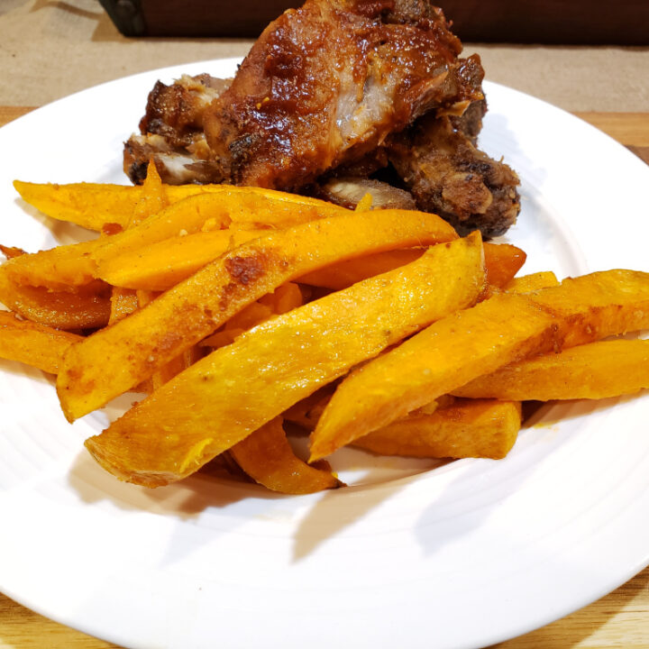 Sweet Potato Fries with Ribs in the Background on a white plate