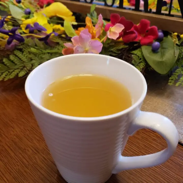 Lemon Ginger Tea in a white mug with Spring flowers in the background