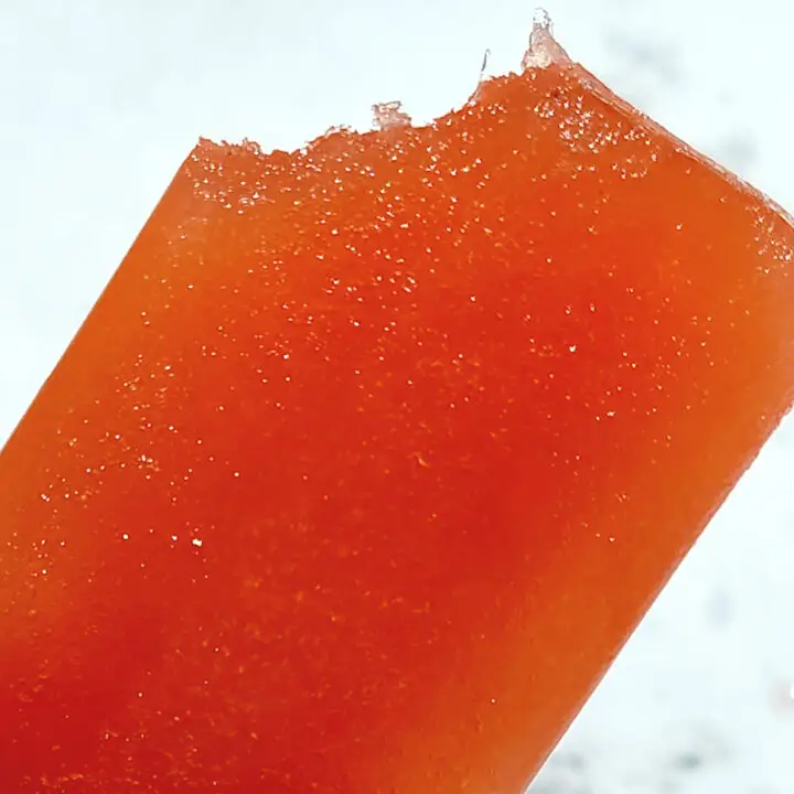 Strawberry Lemonade Popsicles with a bite taken from the corner