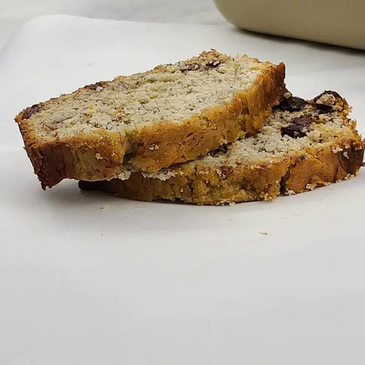 Two slices of banana bread staked on piece of paper.